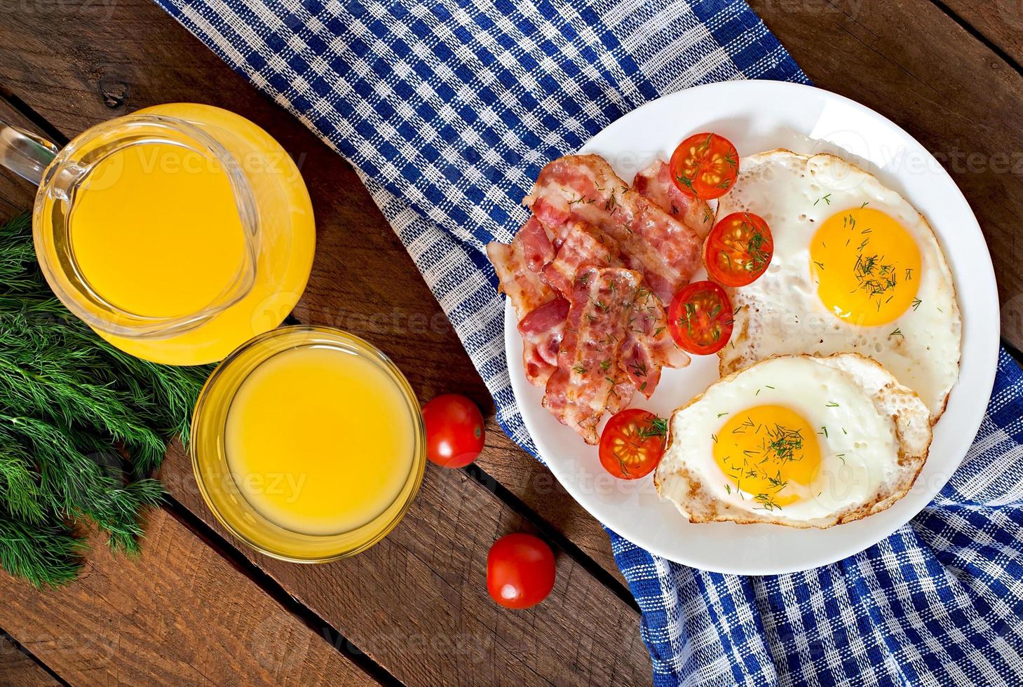 English breakfast - toast, egg, bacon and vegetables in a rustic style on wooden background photo