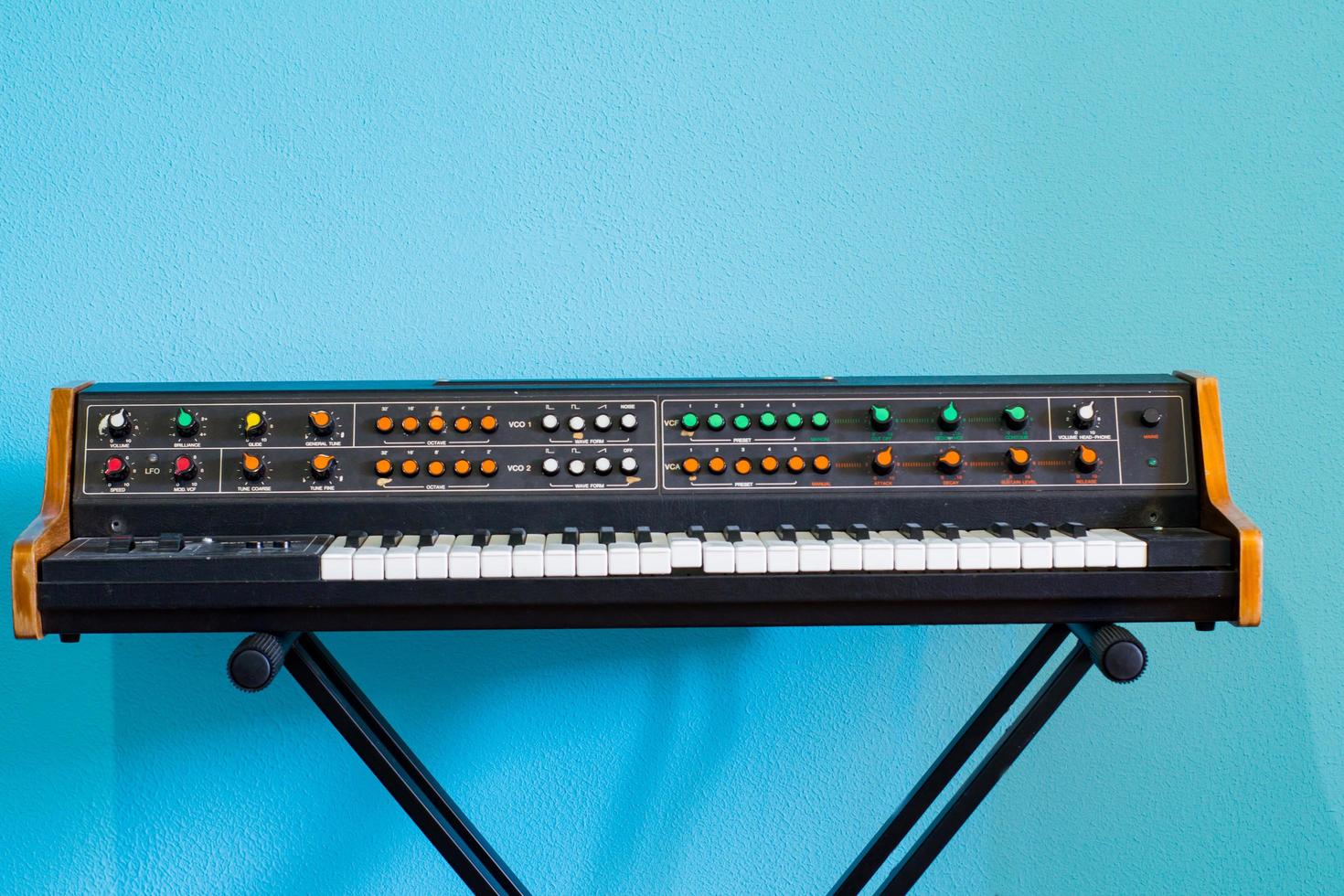 Old synthesizer with colorfull switches on blue background photo