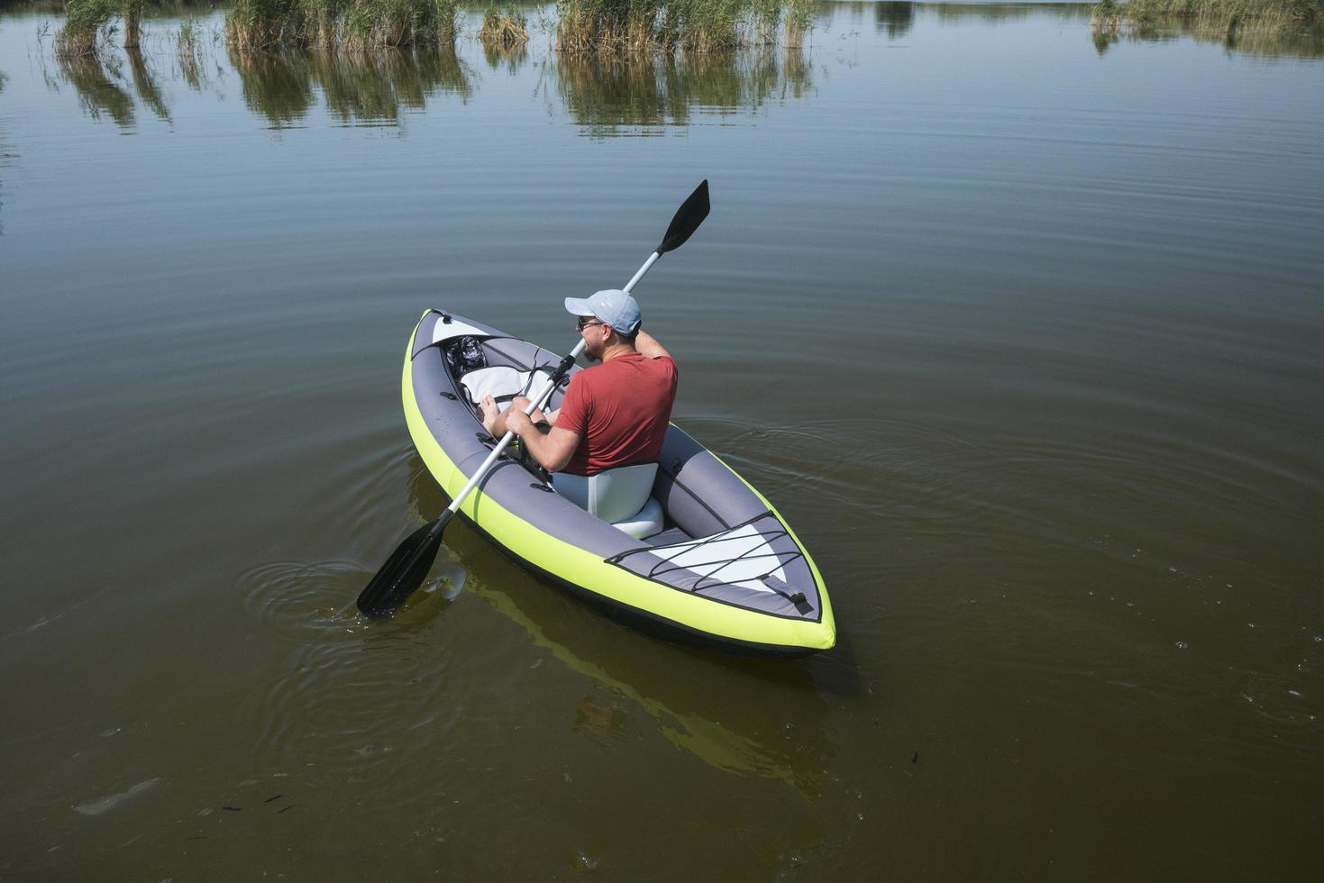 young male swim on kayak on the river photo