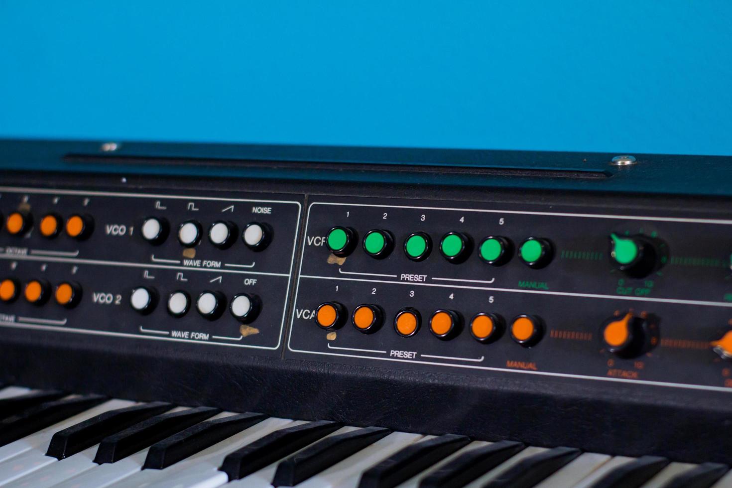 Old synthesizer with colorfull switches on blue background photo