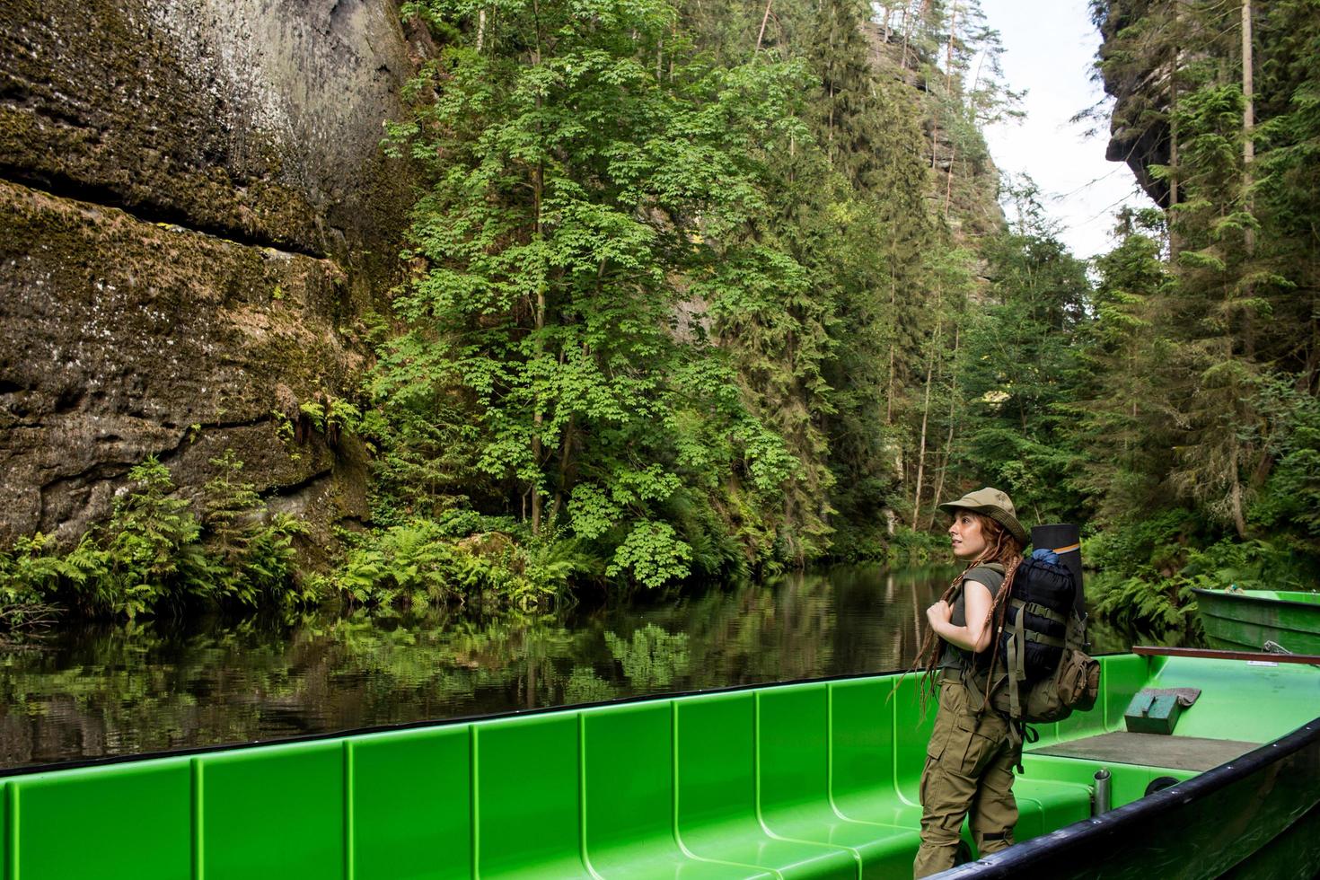 Young woman hiker posing near the river in bohemian switzerland national park, female traveler in mountains of czech republic photo