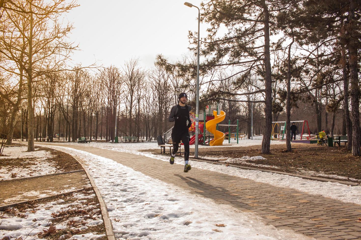 young runner training outdoor in winter park photo