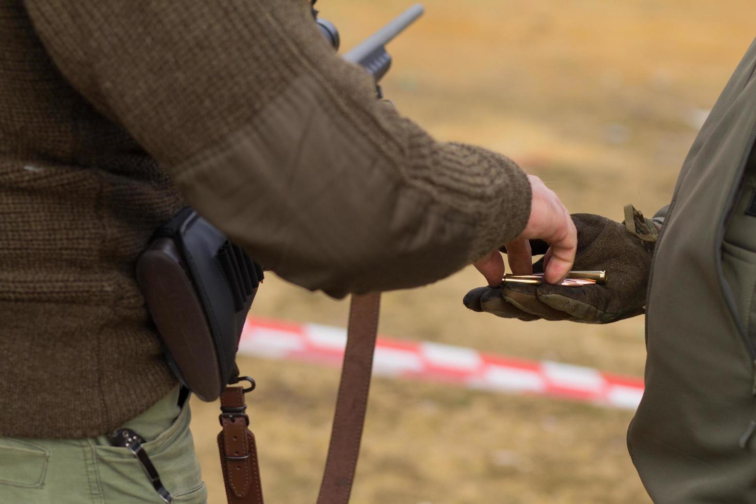 Male training with pump action shotgun outdoors in field. photo