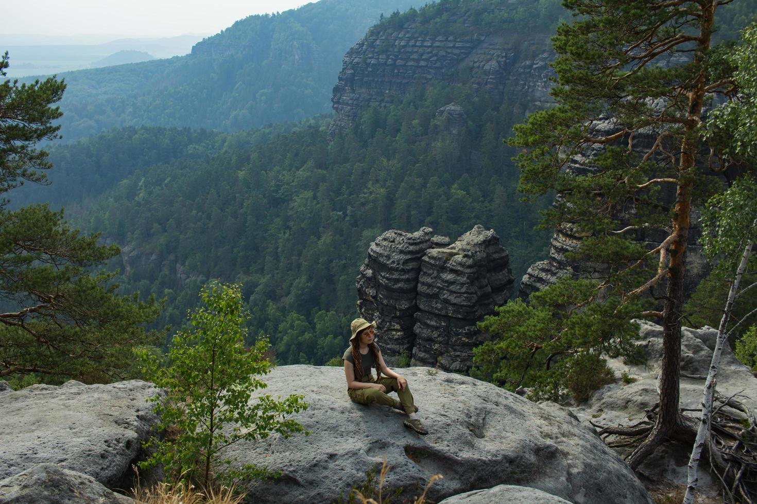 Young woman hiking on the spring meadow, mountains and forest on background photo