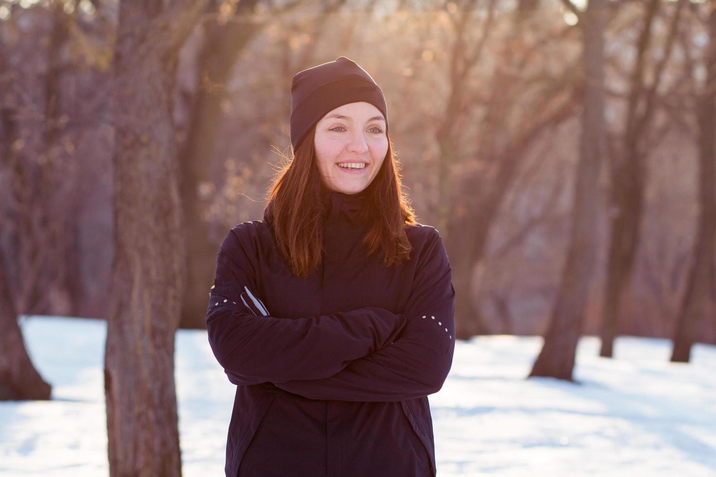 joven atleta con traje deportivo negro corre en el parque de invierno foto