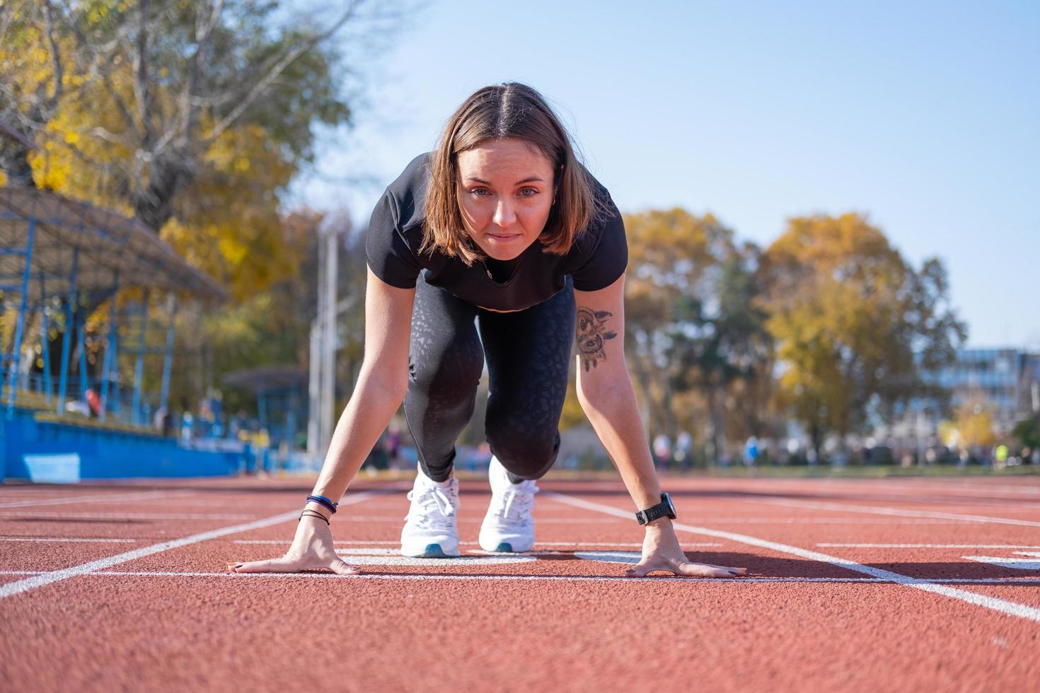 Young female runner training in summer day outdoors on the studium photo