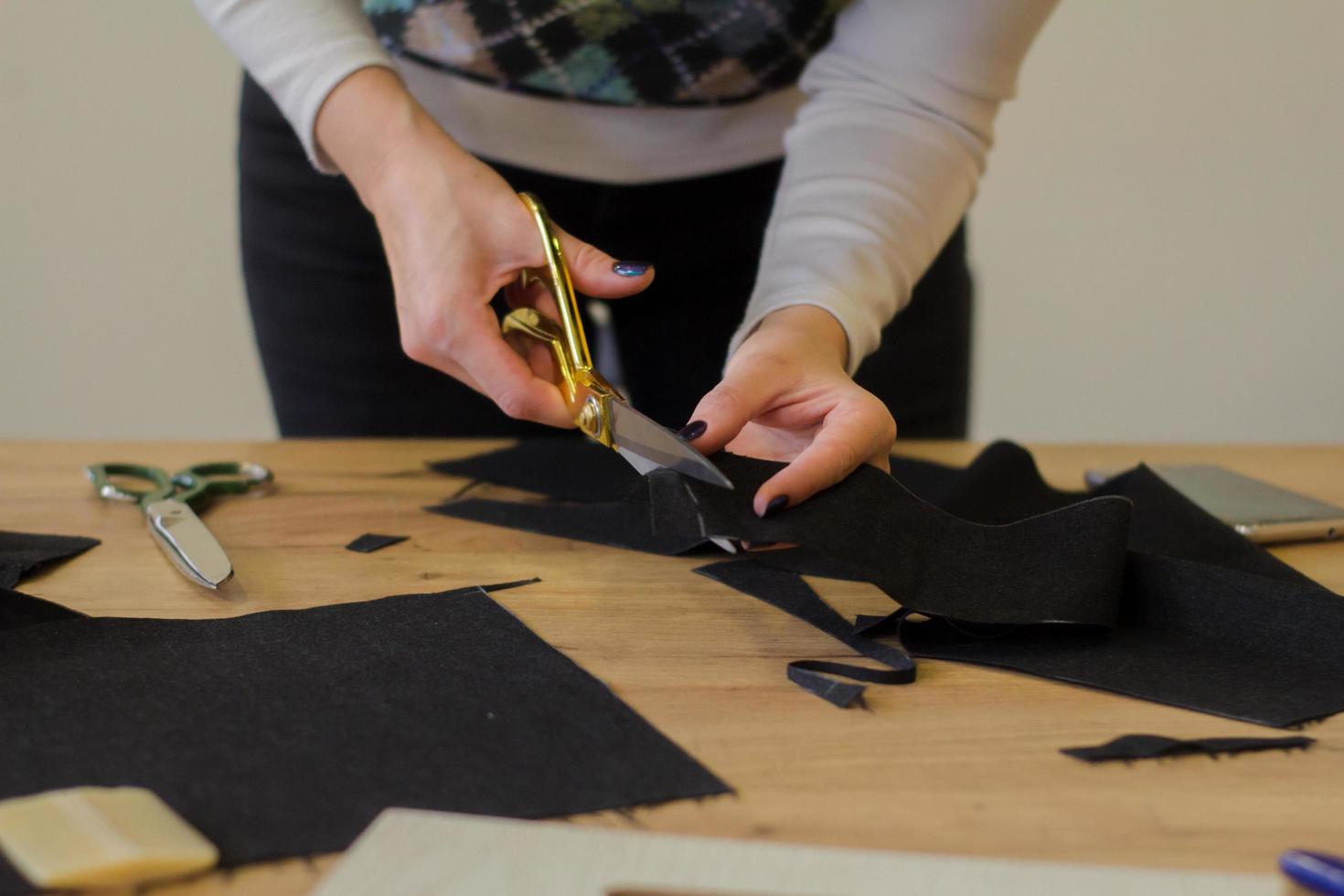 seamstress at work on the table, tailor woman work in studio with clothes photo
