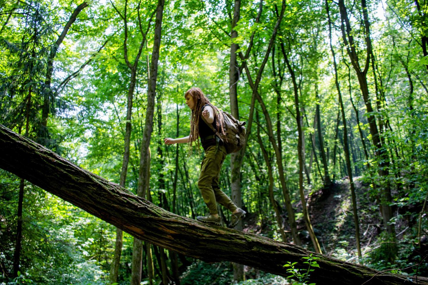 Young woman hiking on the spring meadow, mountains and forest on background photo