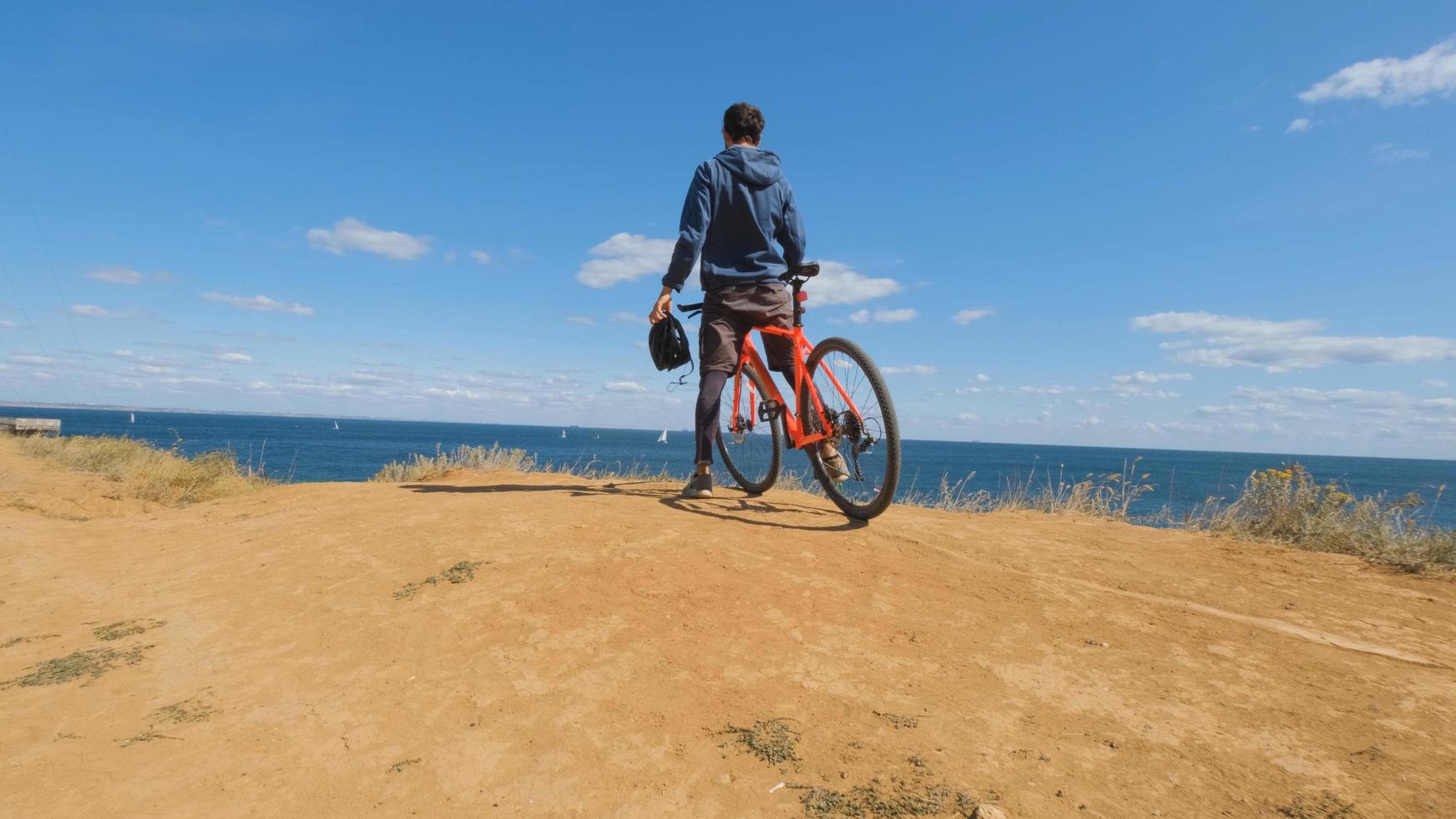 Young male on the bicycle with helmet ride on the beach photo