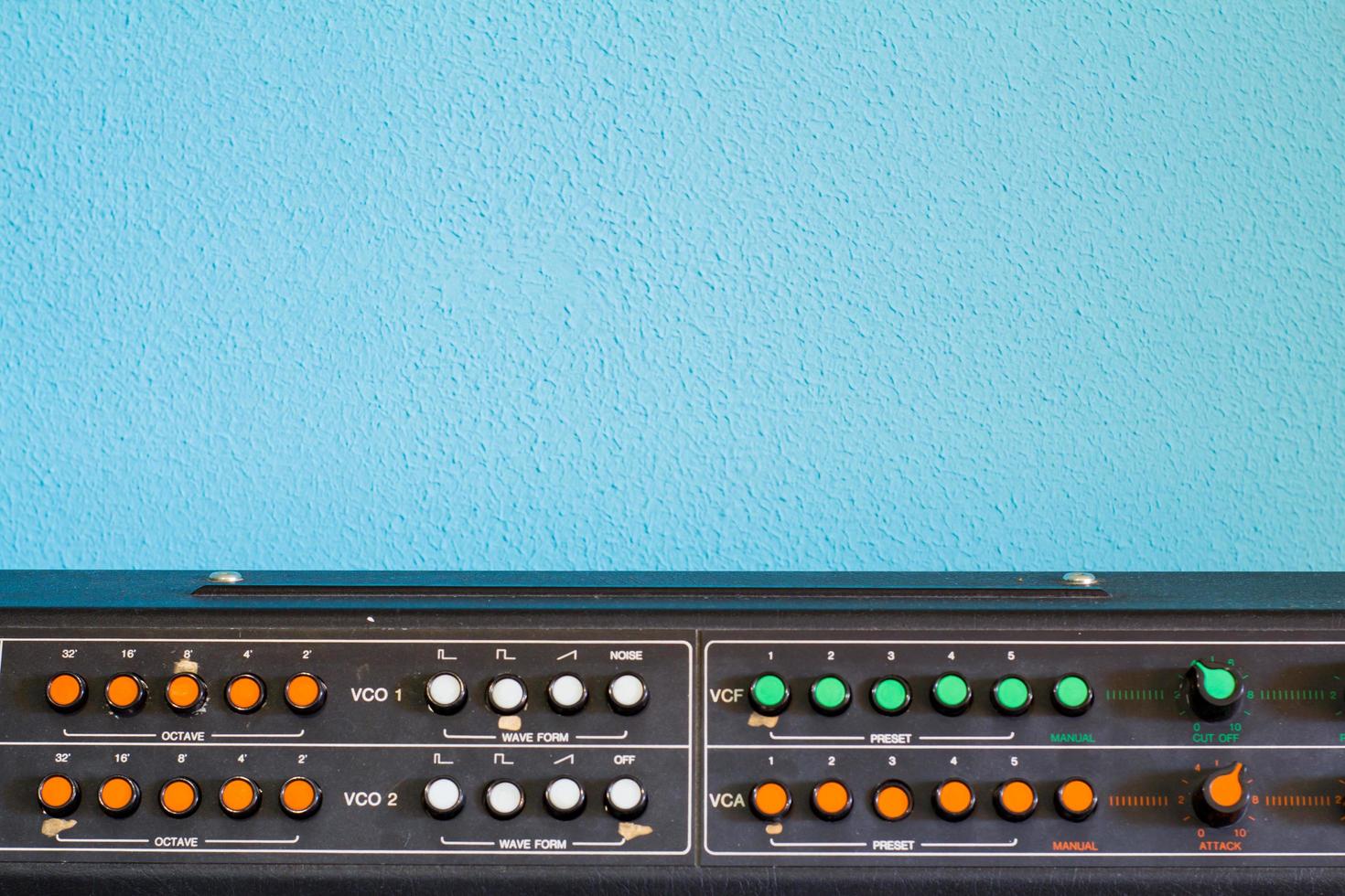 Old synthesizer with colorfull switches on blue background photo