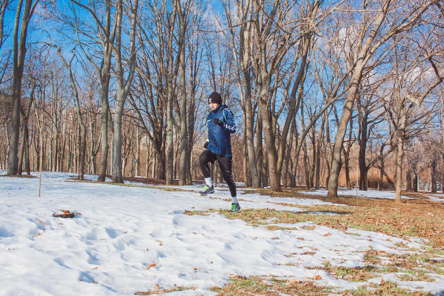 young runner training outdoor in winter park photo