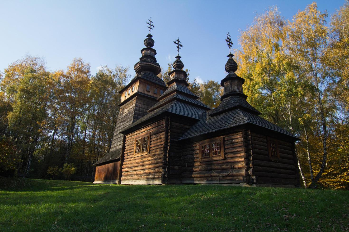 Old wooden house in beautiful autumn forest photo