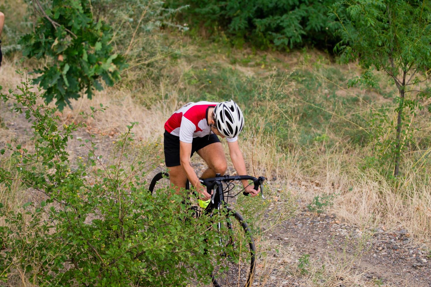 Biycle rider on cyclocross bike training outdoor on gravel country road photo