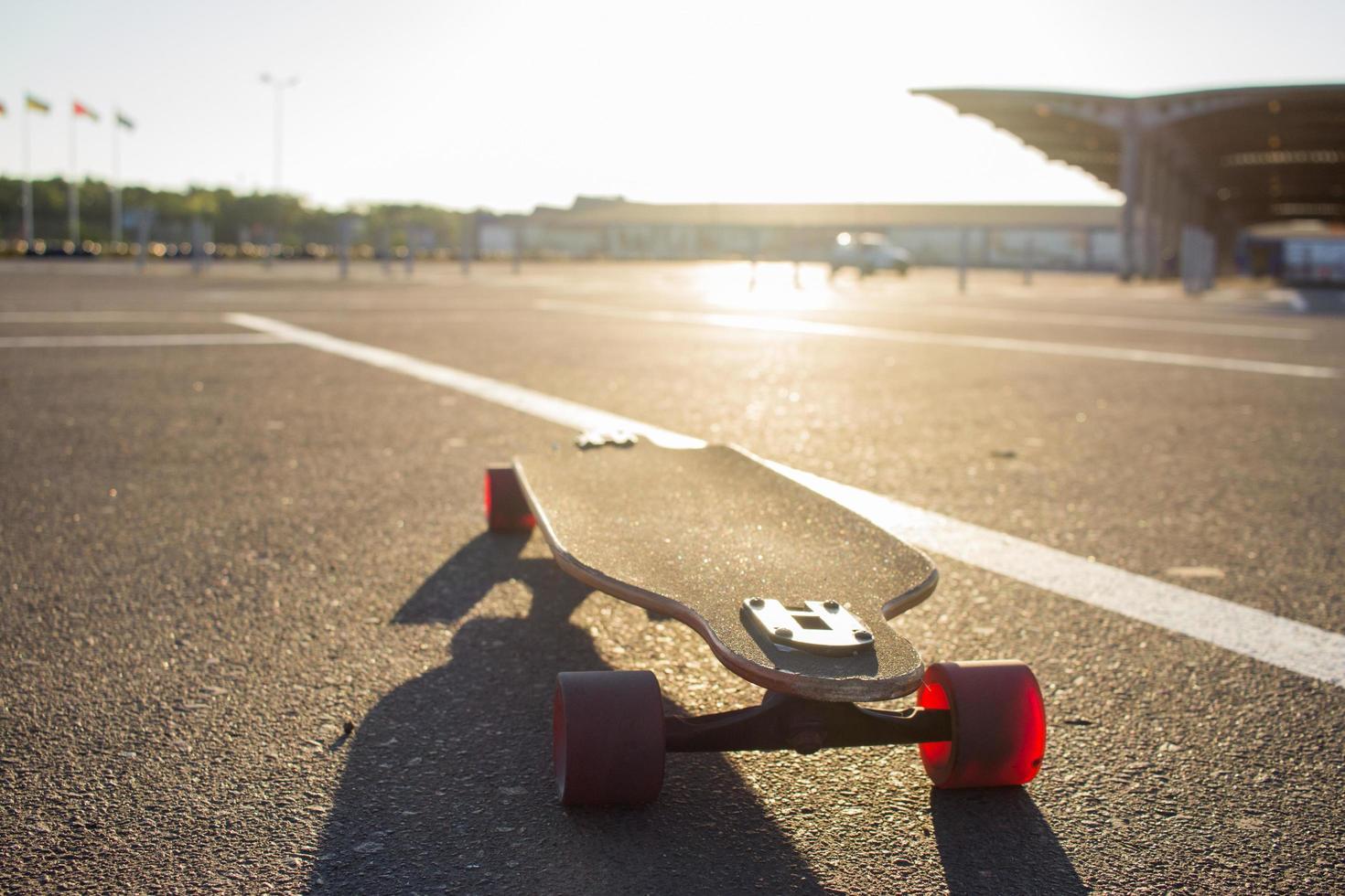 longboard skate stand alone on asphalt in yellow sunlight photo