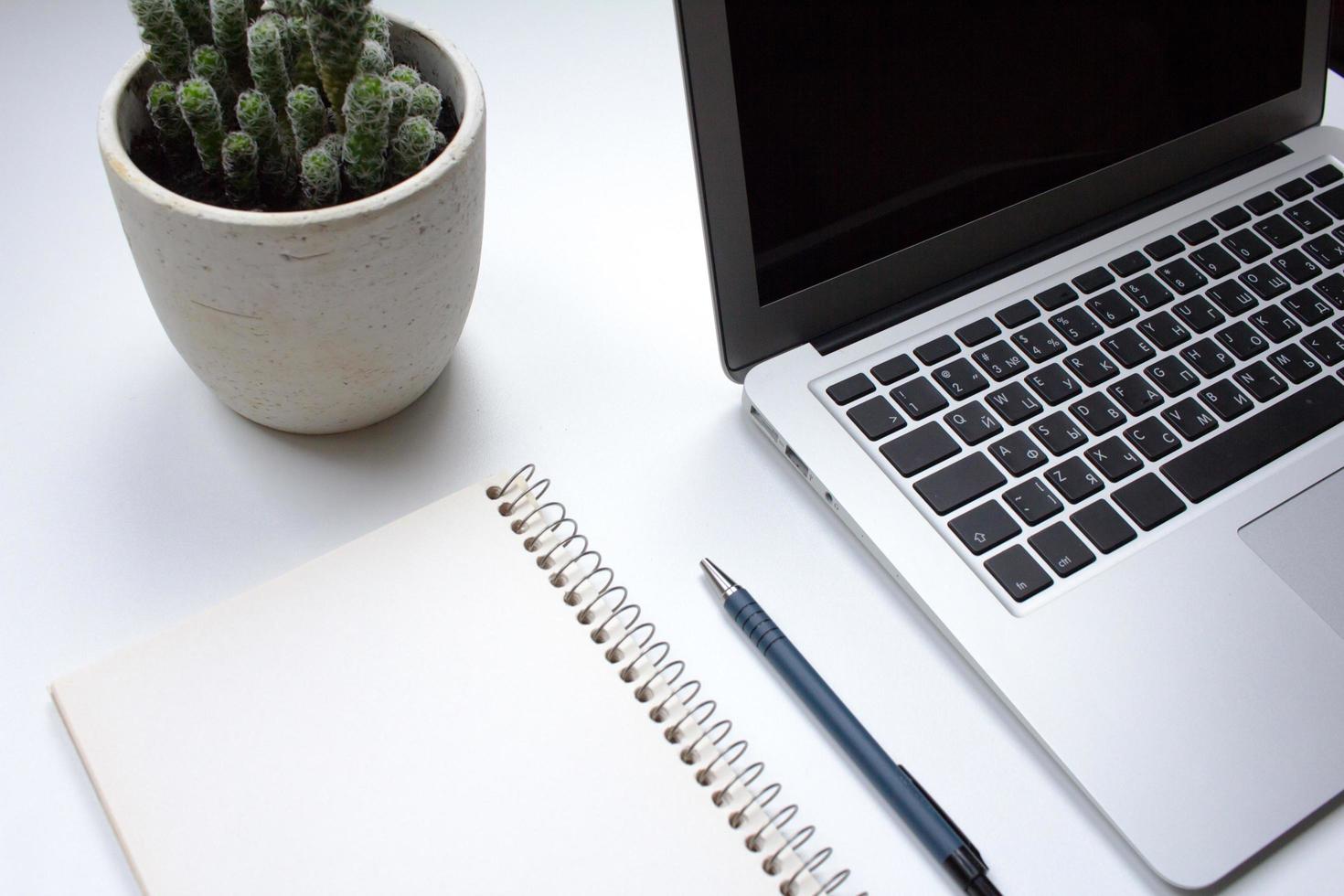 notebook on white table with gadgets and decorations, top view of writer, freelancer or buisinessman work place photo