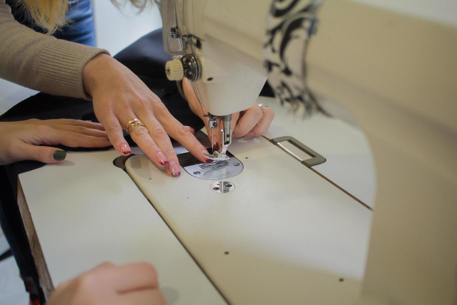 costurera en el trabajo sobre la mesa, sastre mujer trabaja en estudio con ropa foto