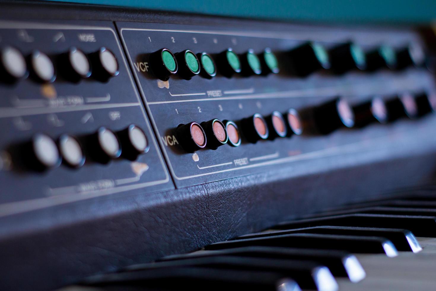 Old synthesizer with colorfull switches on blue background photo