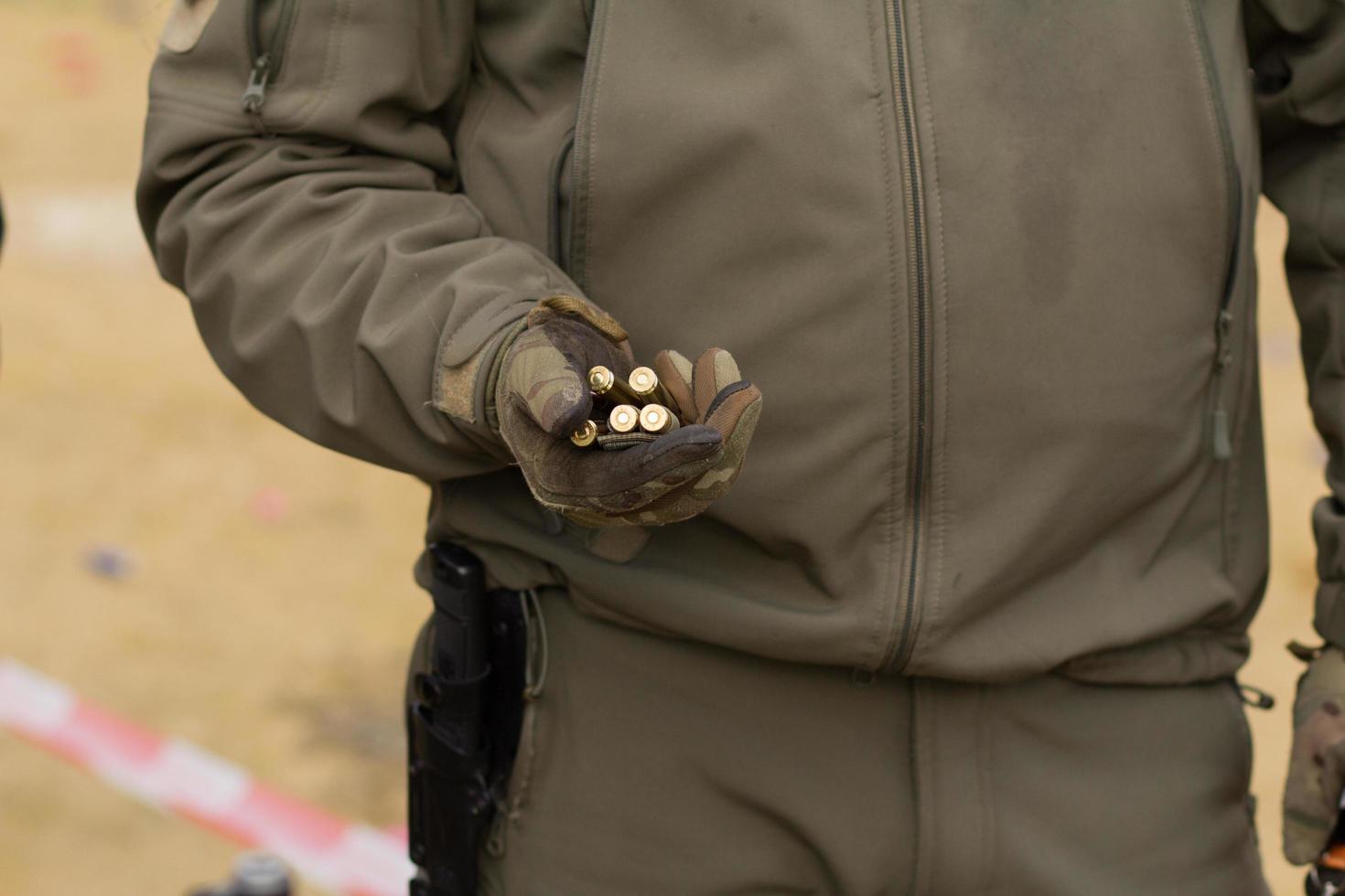 Male training with pump action shotgun outdoors in field. photo
