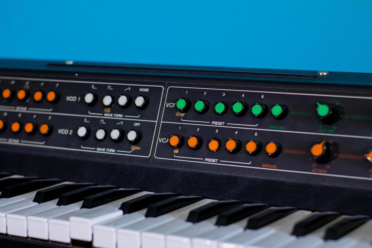 Old synthesizer with colorfull switches on blue background photo