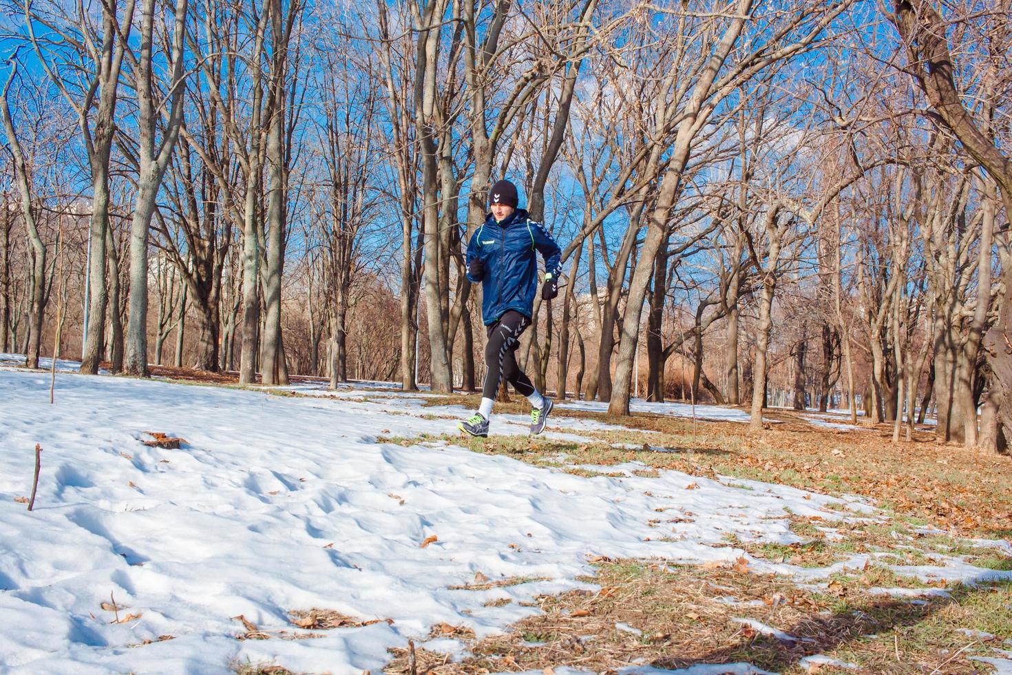 young runner training outdoor in winter park photo