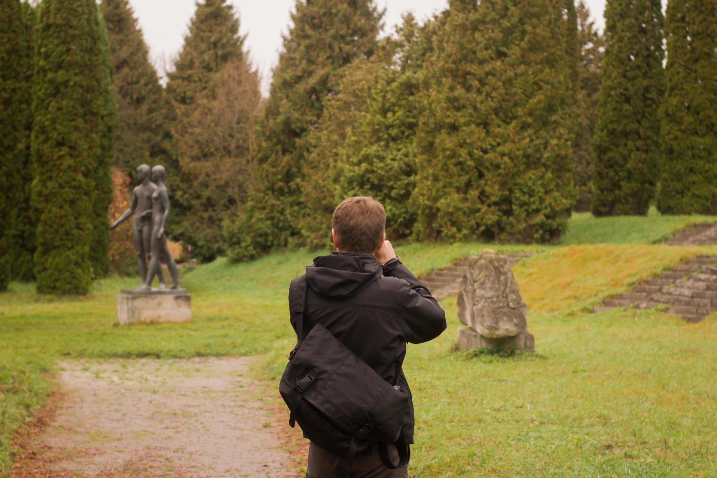 maletourist hace una foto en el hermoso parque de otoño