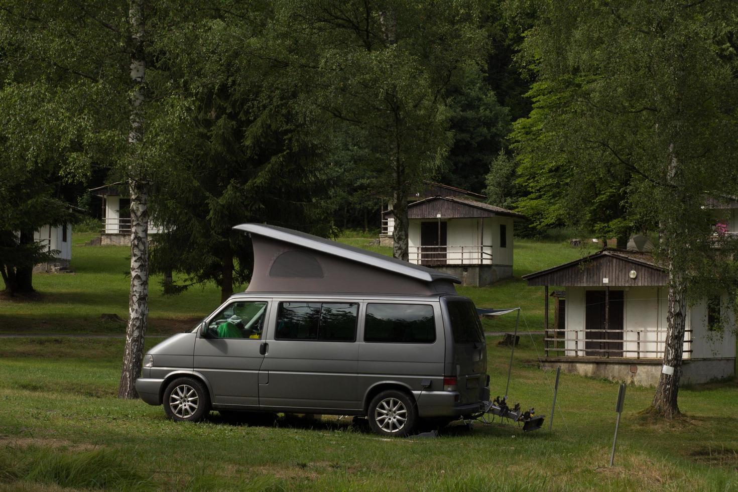 Bus with tent on the camping in the forest photo