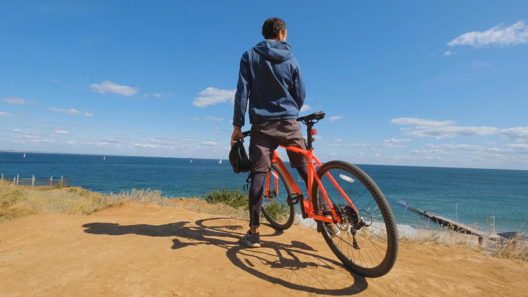 Young male on the bicycle with helmet ride on the beach photo