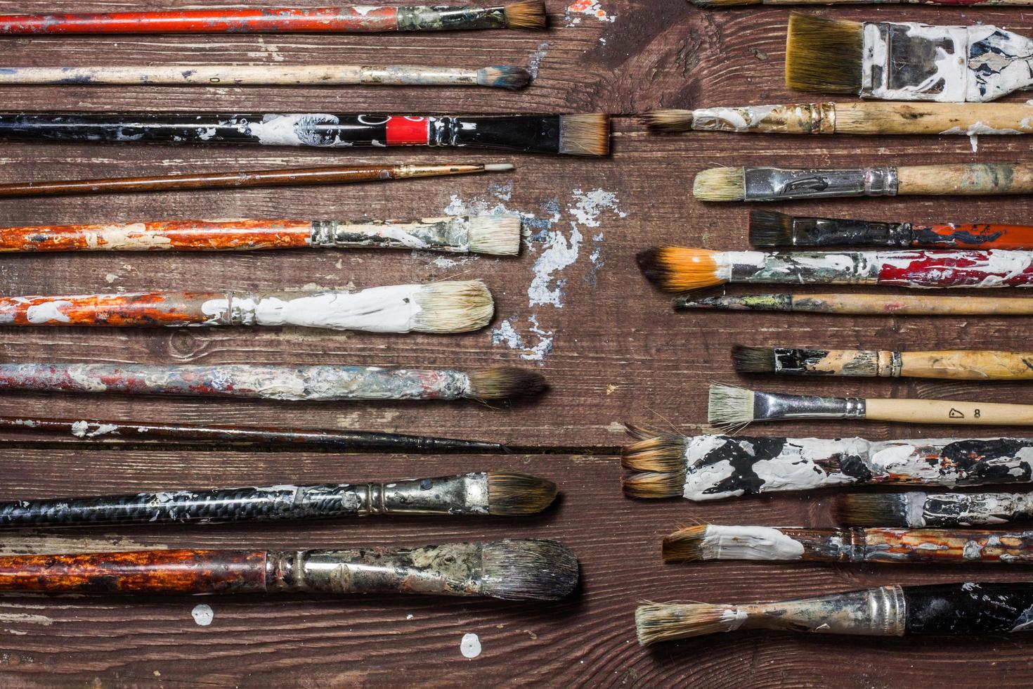 Brushes for painting lie on the old wooden rustic table in the artist's studio photo