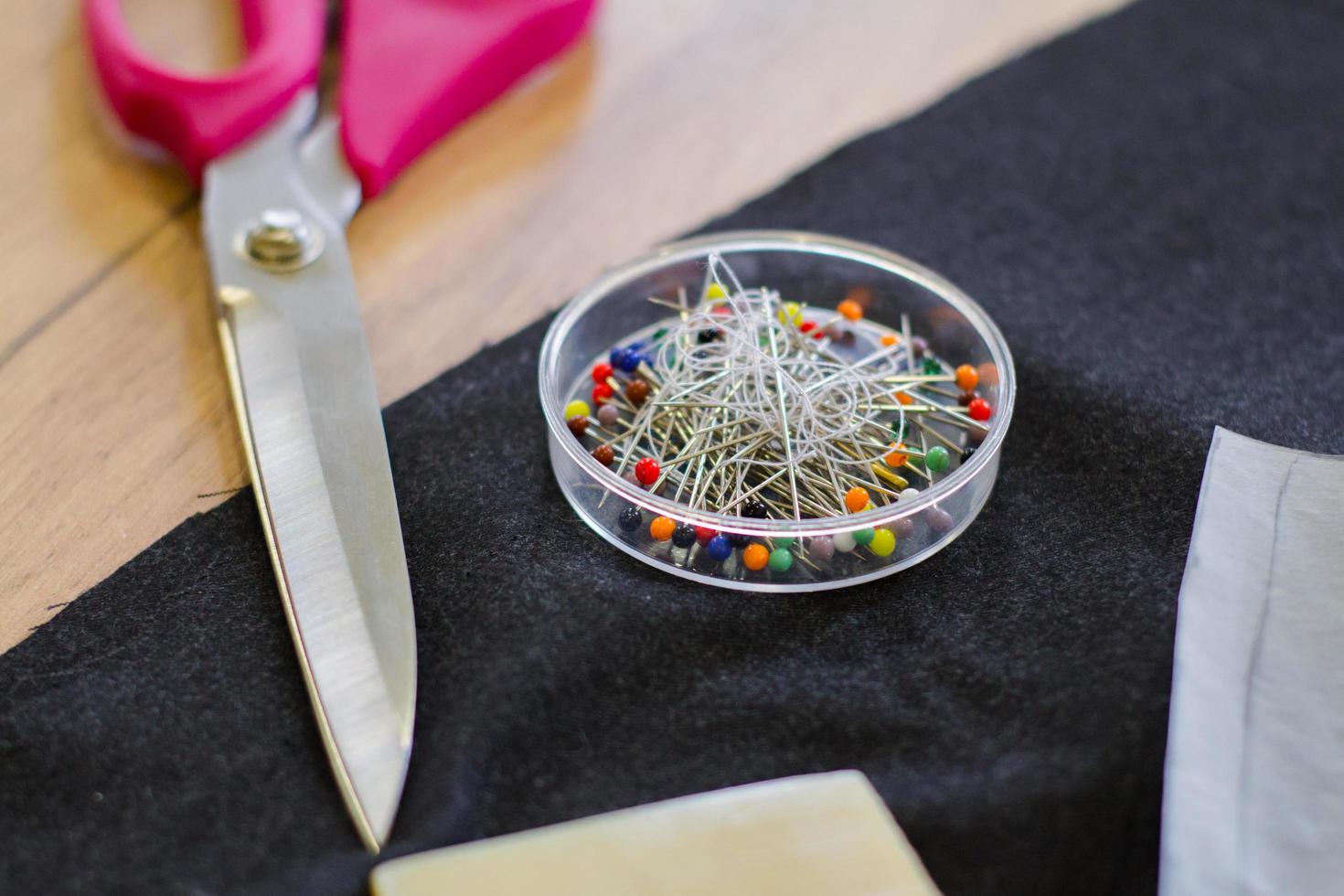 Sewing accessories, tools and cloth on seamstress table photo