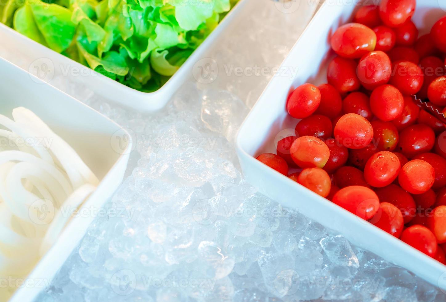 Salad bar buffet at restaurant. Fresh salad bar buffet for lunch at event in hotel. Healthy food. Fresh tomatoes, lettuce, onions sliced in bowl on crushed ice counter. Catering food. Banquet service. photo