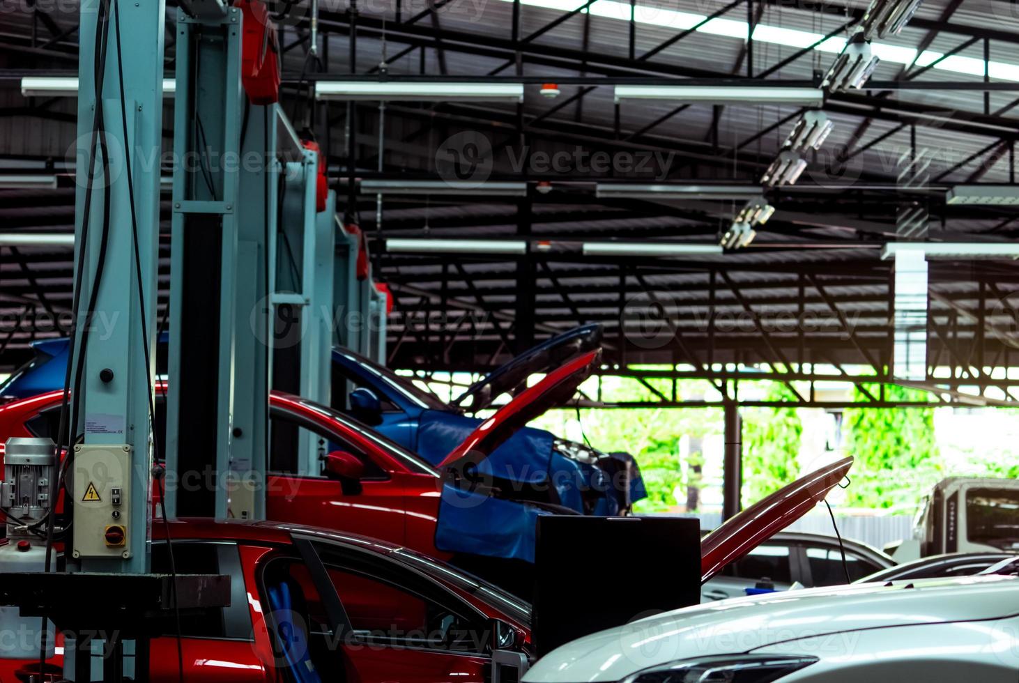 Auto repair shop. SUV car is lift in garage for repair and maintenance service. Auto service with lifted vehicle. Car body lifted in workshop for inspection. Car check up at service station. photo