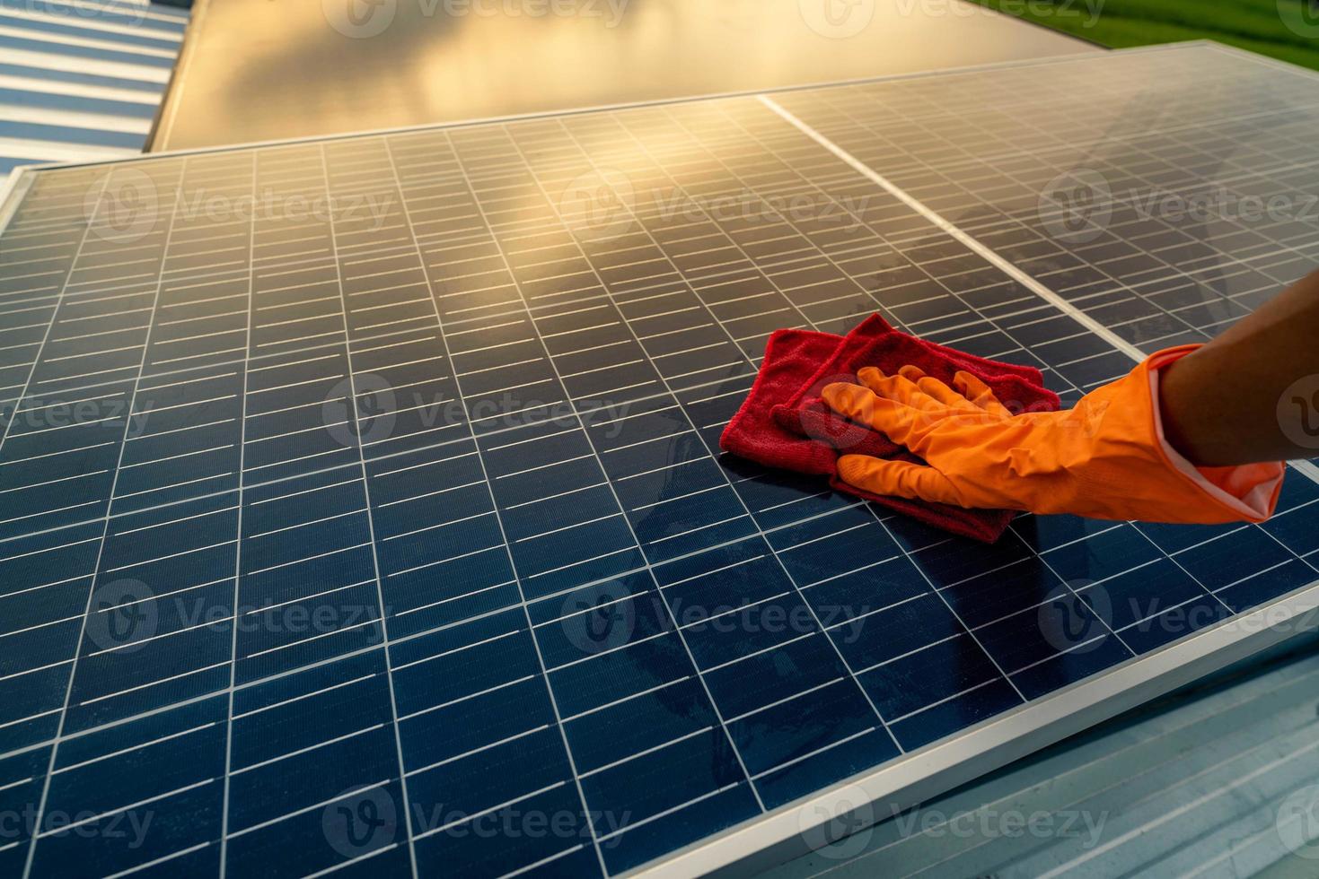 hombre limpiando panel solar en el techo. mantenimiento de paneles solares o módulos fotovoltaicos. recurso sostenible y energía renovable para el concepto verde. energía solar para energía verde. tecnología para el futuro. foto