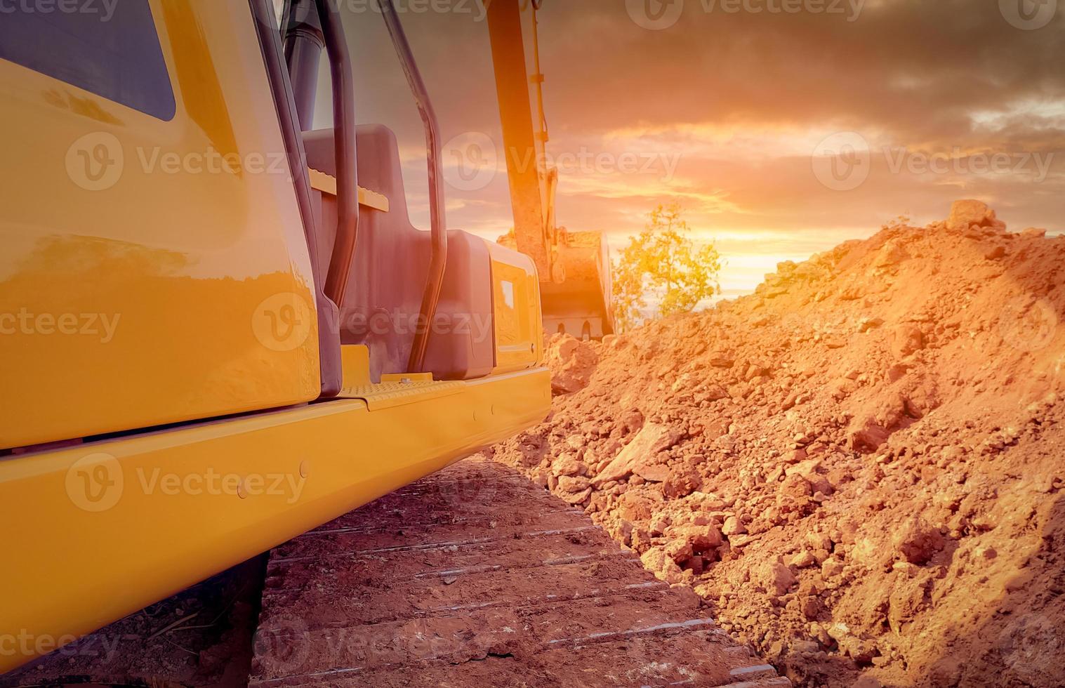 Back view backhoe working by digging soil at the construction site. Crawler excavator digging on demolition site. Excavating machine. Earthmoving equipment. Excavation vehicle. Construction business. photo