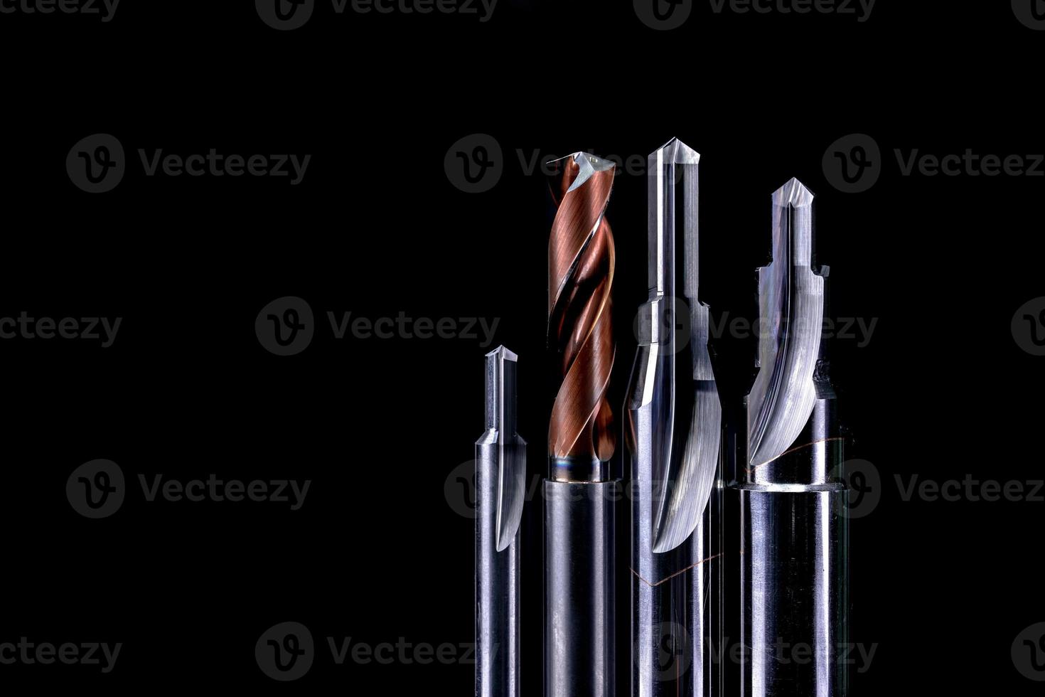 Special tools isolated on dark background. Made to order special tools. Coated step drill and reamer detail. HSS cemented carbide. Carbide cutting tool for industrial applications. Engineering tools. photo