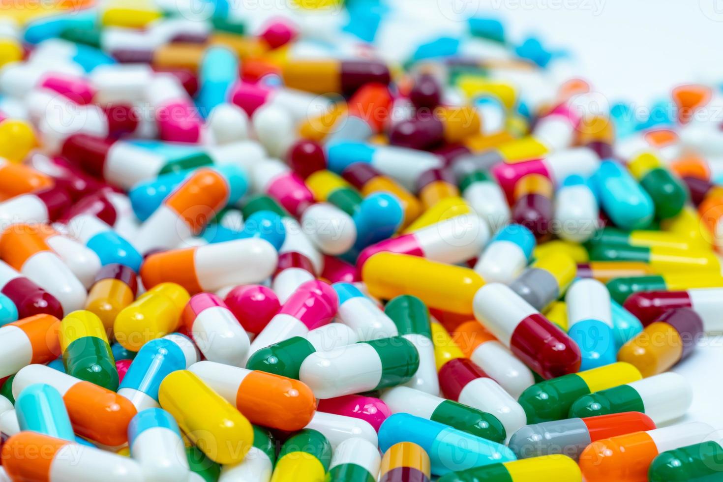 Selective focus on multi-colored antibiotic capsule pills. Antibiotic drug resistance concept. Pile of colorful capsule pills. Pharmaceutical industry. Antimicrobial drug for treatment infection. photo