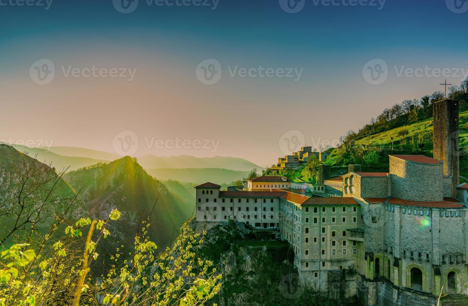 Old building at the edge of rock mountain in the morning with sunrise sky. Mountain range with fog in front of hotel. Beautiful Europe building at hill. Old architecture in spring season in Spain. photo