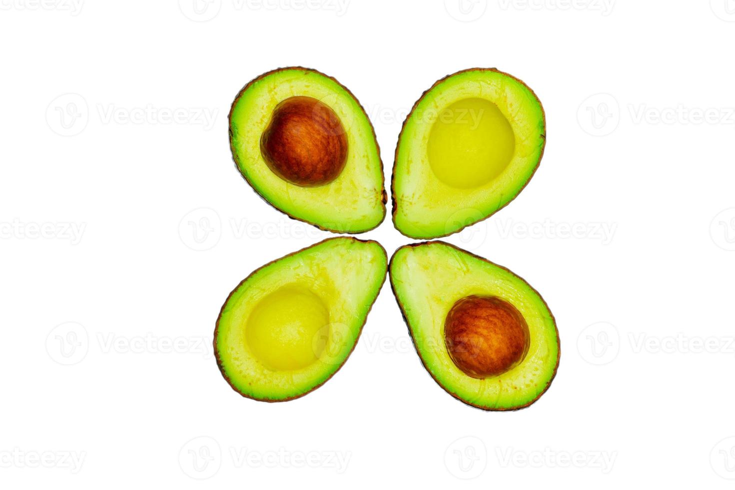 aguacate con semilla aislado sobre fondo blanco. fuente de omega 3 de la alimentación natural. alimentos saludables para el bebé. medias piezas de aguacates dispuestas con un hermoso patrón de flores. alimentos orgánicos para vegetarianos. foto