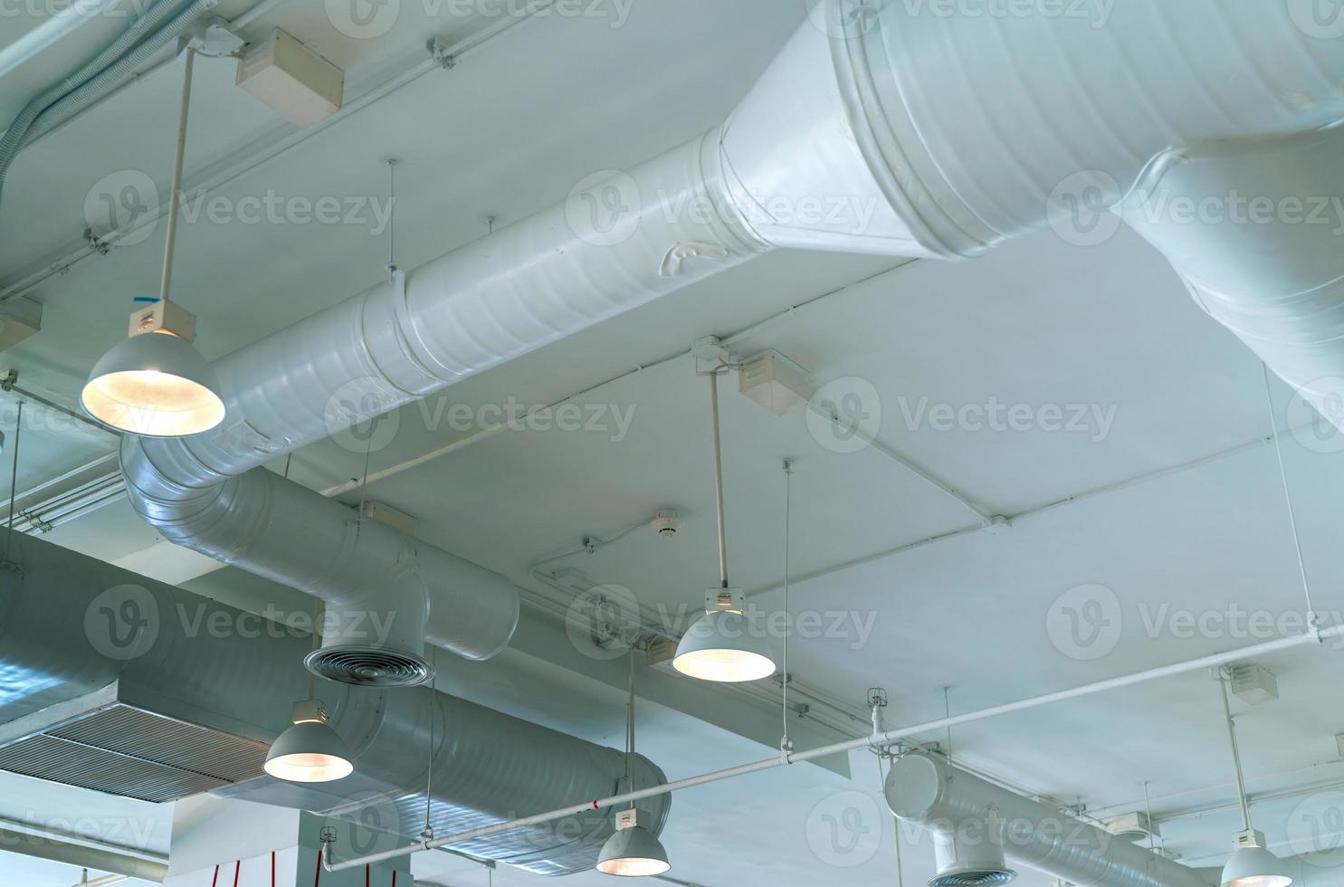 Air duct, air conditioner pipe, wiring pipe, and fire sprinkler system. Air flow and ventilation system. Building interior. Ceiling lamp light with opened light. Interior architecture concept. photo