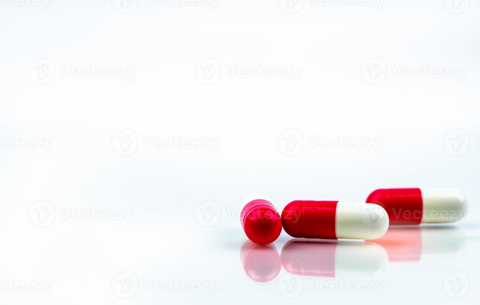 Red-white capsule pill isolated on white background. Antibiotic drug resistance. Antimicrobial capsule pills. Pharmacy drugstore symbol. Pharmaceutical industry. Healthcare medication. Three capsule. photo