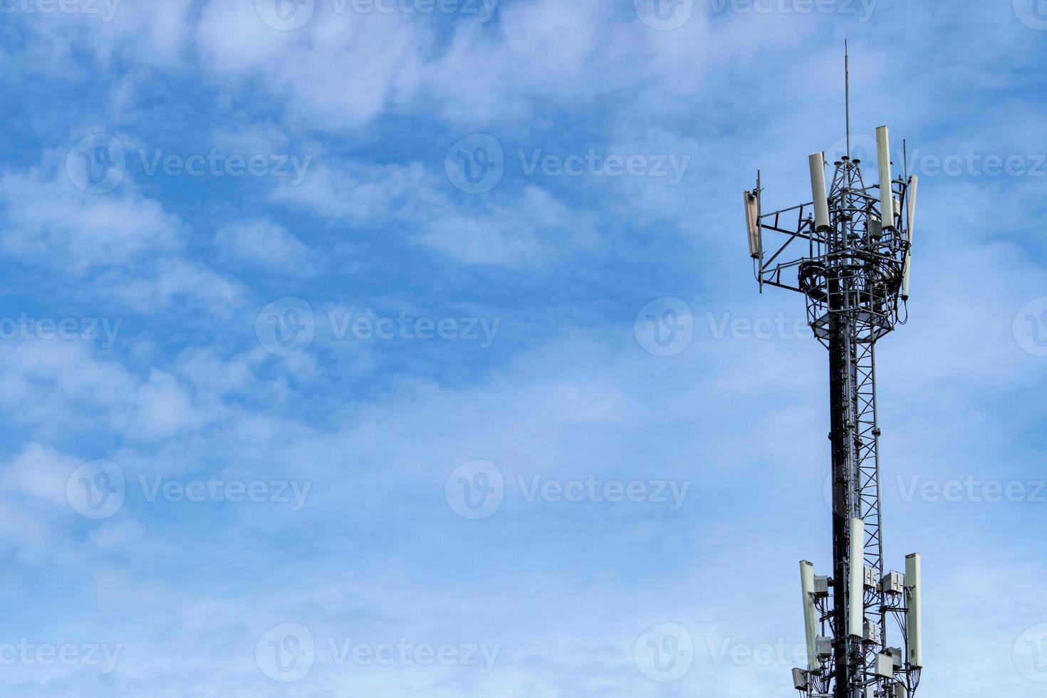 Telecommunication tower with blue sky and white clouds background. Antenna on blue sky. Radio and satellite pole. Communication technology. Telecommunication industry. Mobile or telecom 4g network. photo