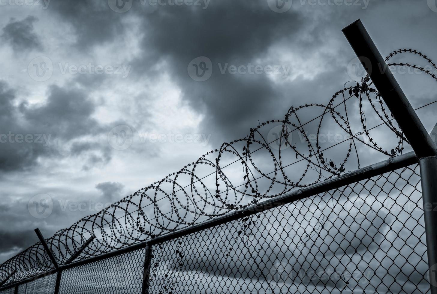 Prison security fence. Barbed wire security fence. Razor wire jail fence. Barrier border. Boundary security wall. Prison for arrest criminals or terrorists. Private area. Military zone concept. photo