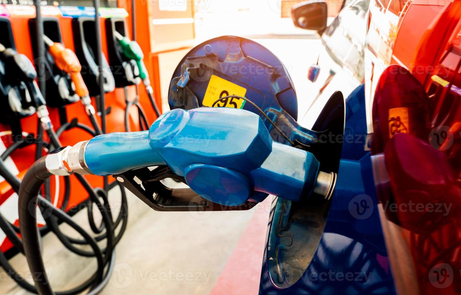 repostaje de coches en la gasolinera. repostar llenar con gasolina gasolina. bomba de gasolina que llena la boquilla de combustible en el tanque de combustible del automóvil en la gasolinera. industria y servicio de gasolina. precio de la gasolina y concepto de crisis del petróleo. foto