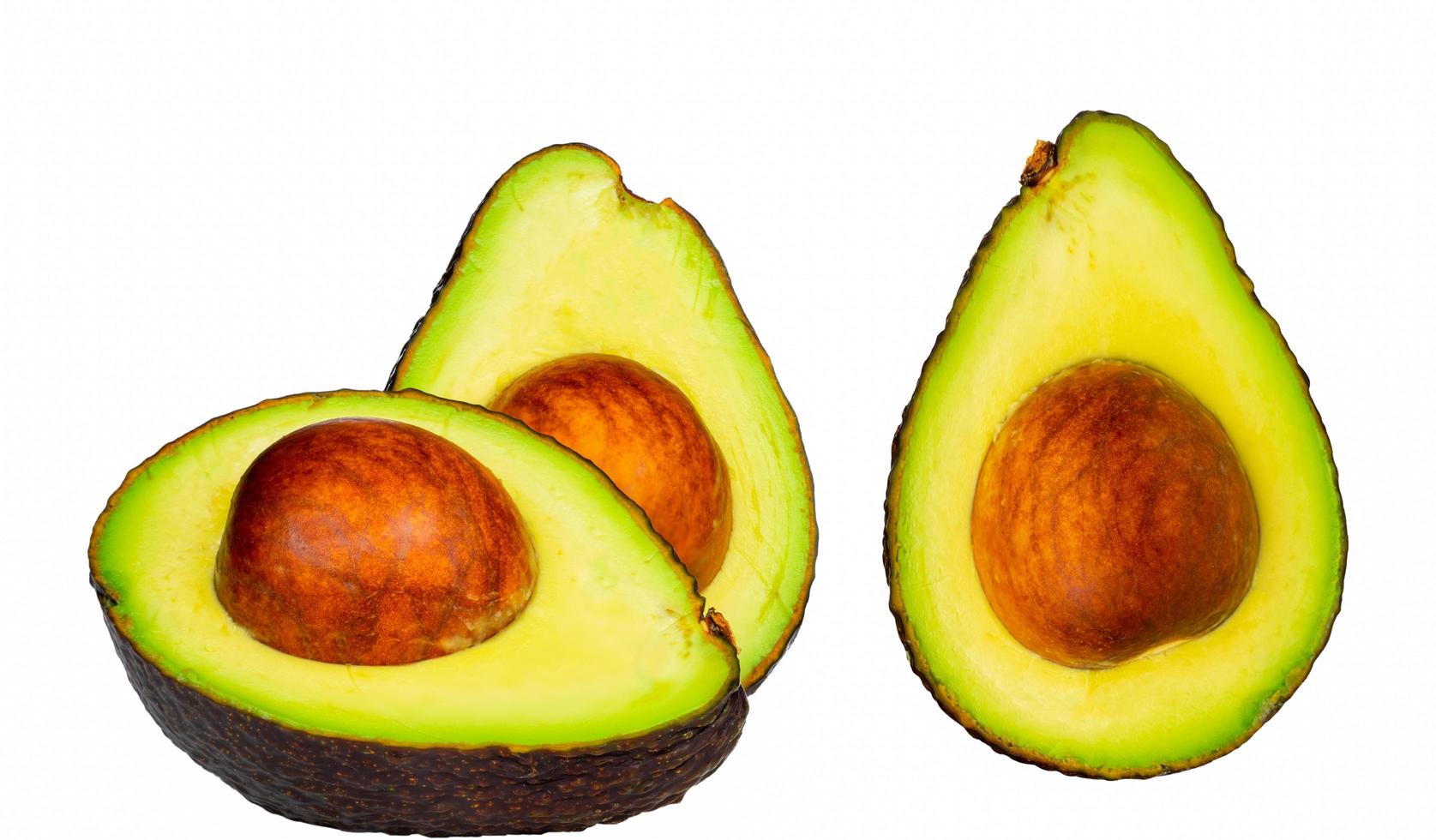 Avocado with seed isolated on white background. Source of omega 3 from natural food. Healthy food for baby. Half pieces of avocados arranged with beautiful pattern. Organic food for vegetarian. photo