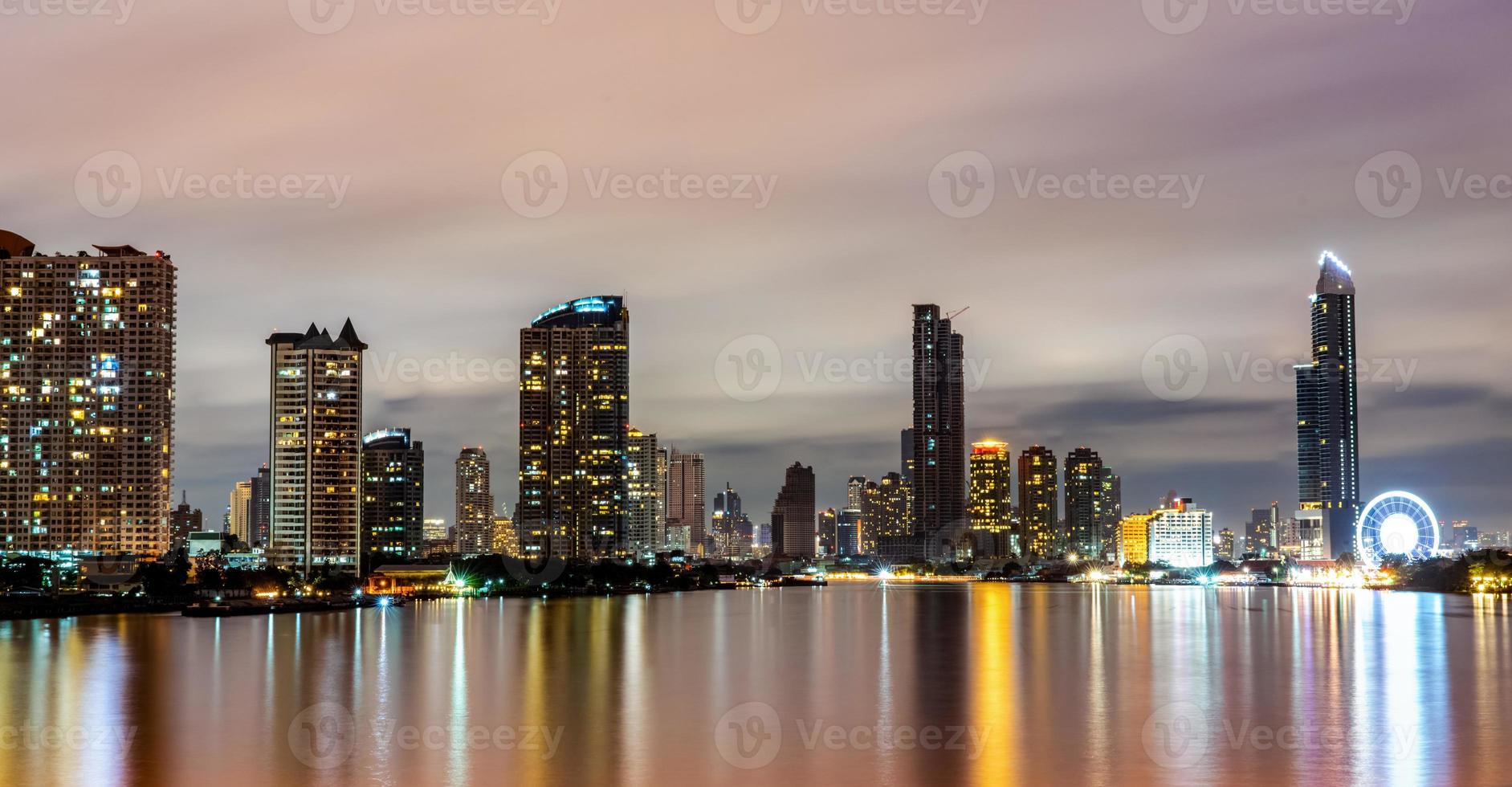 Cityscape of modern building near the river in the night. Modern architecture office building. Skyscraper with evening sky. Black and white tone picture. Night photography of riverfront building. photo