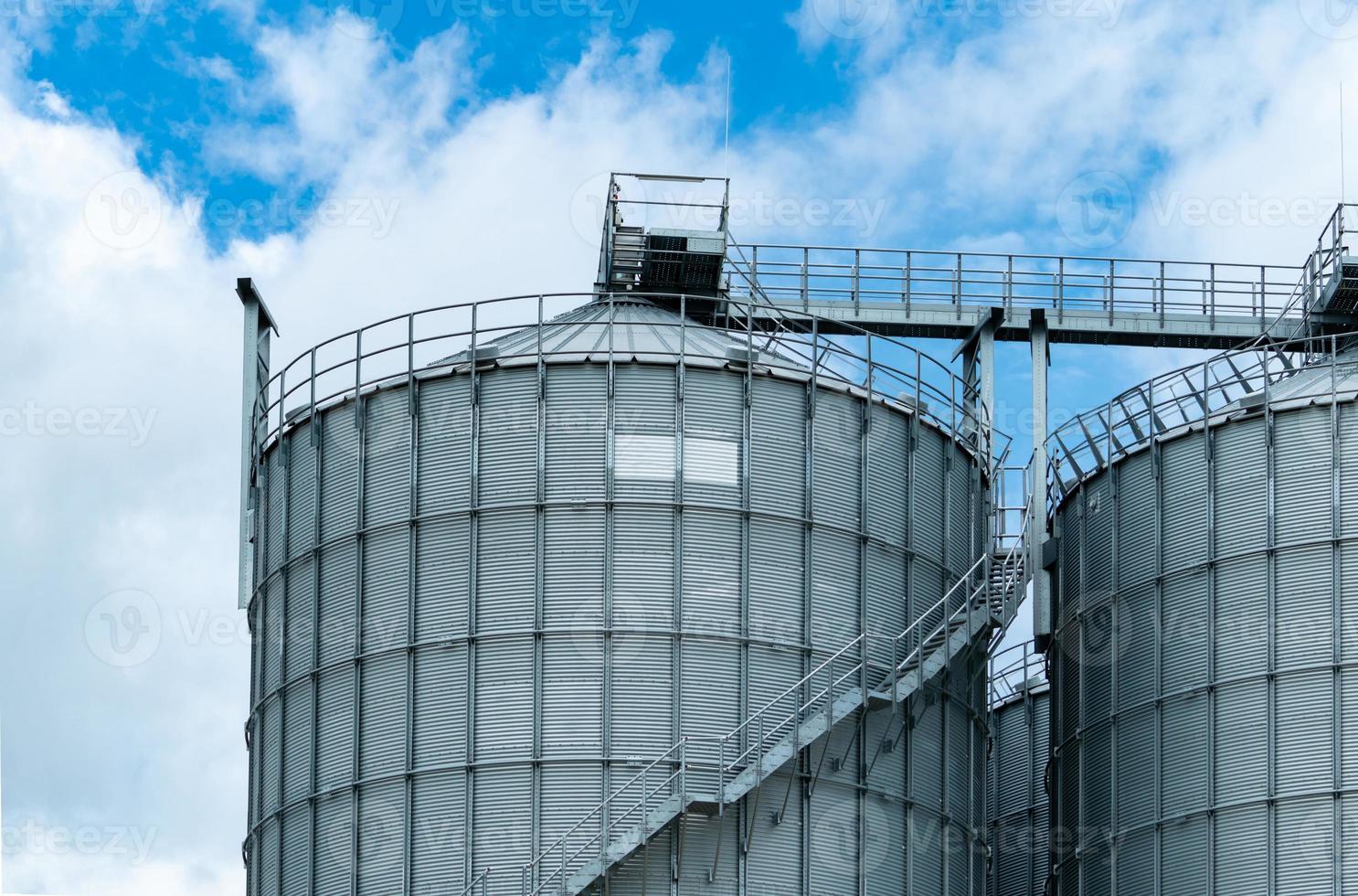 Agricultural silo at feed mill factory. Big tank for store grain in feed manufacturing. Seed stock tower for animal feed production. Commercial feed for livestock, swine and fish industries. photo