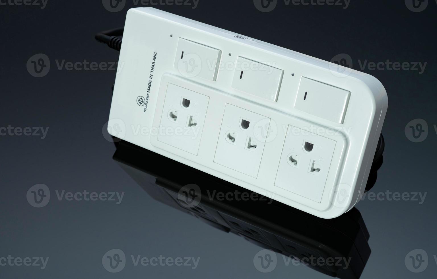 Power strip with three electrical standard socket on black background. White universal plug with overload protection. Fire resistant material for cover. Circuit breaker. Individual switch. Power plug. photo