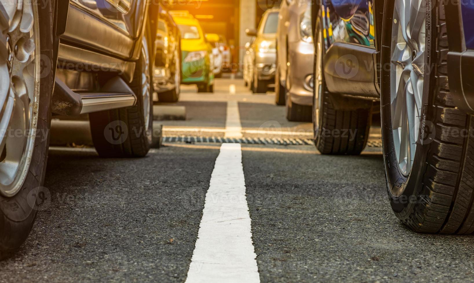 estacionamiento asfaltado del aeropuerto o centro comercial. Se alquila zona de aparcamiento. rueda de primer plano de muchos automóviles estacionados en el estacionamiento de la puerta. industria automotriz. plaza de aparcamiento. mercado mundial de autos usados foto