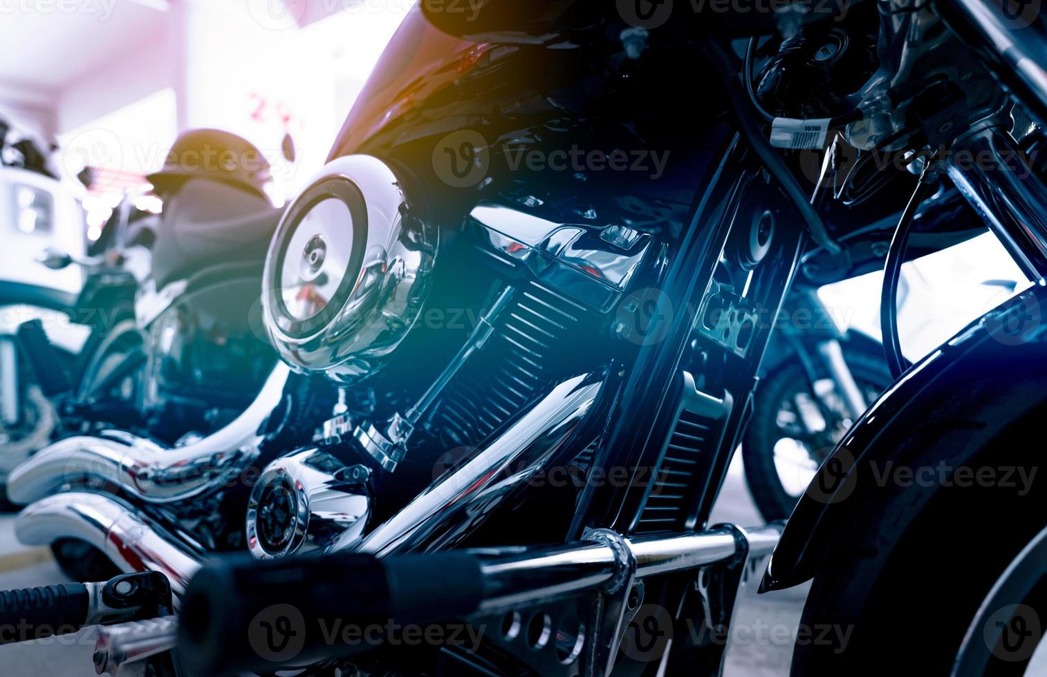 Selective focus on a motorcycle engine. Closeup motorcycle exhaust pipe, engine guard, air filter, and rear brake pedal. Motorcycle industry. Shiny chrome motorbike engine. Vintage motorbike. photo