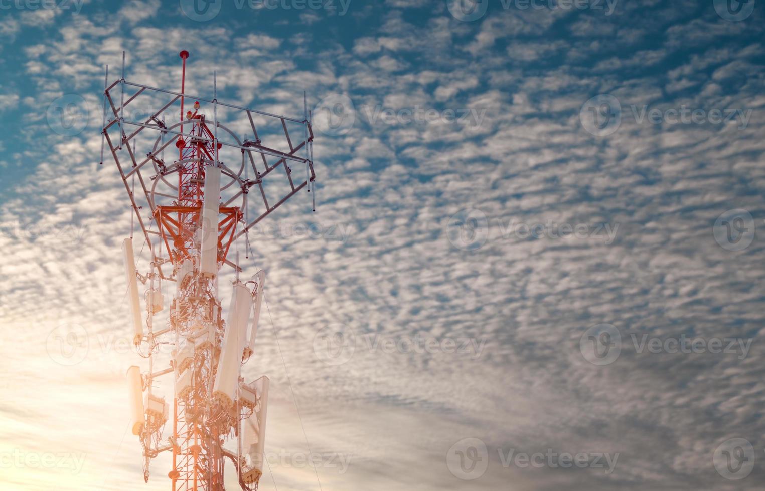 Telecommunication tower with blue sky and white clouds background. Antenna on blue sky. Radio and satellite pole. Communication technology. Telecommunication industry. Mobile or telecom 4g network. photo