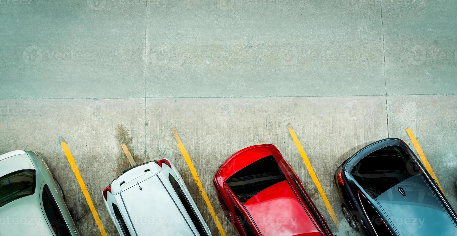 Top view of car parked at concrete car parking lot with yellow line of traffic sign on the street. Above view of car in a row at parking space. No available parking slot. Outside car parking area. photo